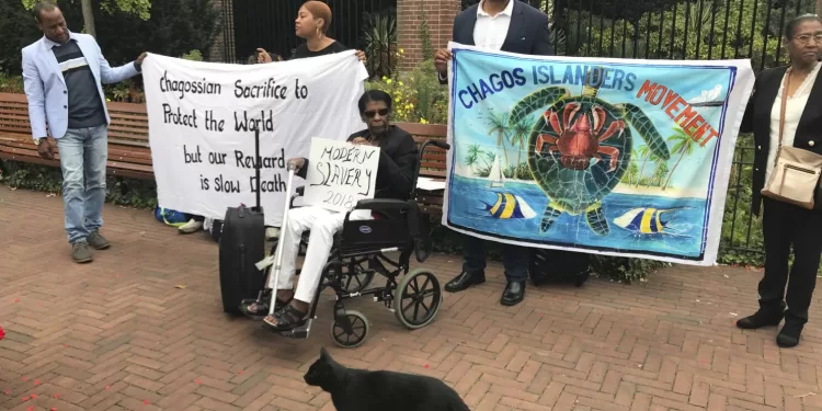 FILE - Protesters hold banners outside the World Court in The Hague, Netherlands, on Sept. 3, 2018, where judges listen to arguments in a case on whether Britain illegally maintains sovereignty over the Chagos Islands. Britain and the United States committed crimes against humanity when they forced the people of the Chagos Islands to leave their homes five decades ago to make way for a U.S. Navy base, a human rights group said Wednesday Feb. 15, 2023 as it called on the two governments to allow the Chagossians to return. (AP Photo/Mike Corder, File)