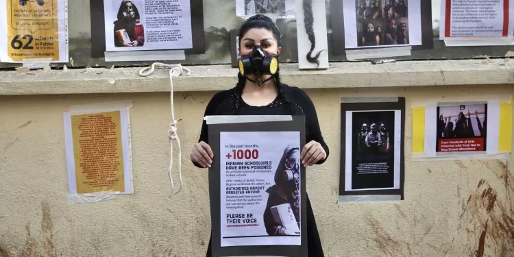 epa10504726 Nikoo Azad, a psychology student from Iran, wears a chemical fume respirator mask and holds a banner during a silent protest in Bangalore, India, 05 March 2023. Nikoo condemned the random toxic gas attacks on 26 girls' schools in Iran, for which no one has been arrested and no chemical agent has been found responsible for the mysterious poisoning of girls.  EPA/JAGADEESH NV