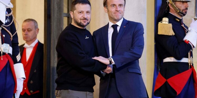 Ukraine's President Volodymyr Zelensky (L) is welcomed by France's President Emmanuel Macron (c) upon his arrival at the Elysee presidential palace in Paris on May 14, 2023. (Photo by Ludovic MARIN / AFP)