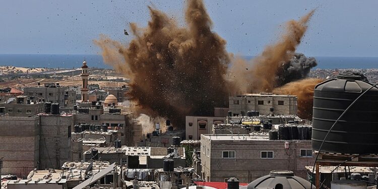 A targeted building is hit during an Israeli airstrike in Rafah in the southern Gaza Strip on May 20, 2021. - Israel and the Palestinians are mired in their worst conflict in years as Israel pounds the Gaza Strip with air strikes and artillery, while Hamas militants fire rockets into the Jewish state. (Photo by SAID KHATIB / AFP)