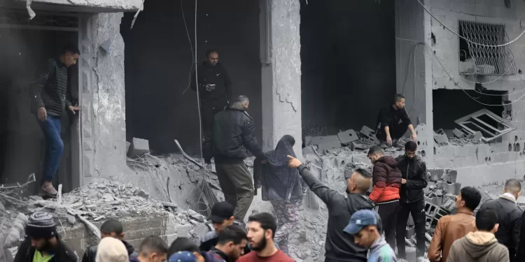 Palestinians look for survivors in the rubble of a building damaged during an Israeli strike on Rafah in the southern Gaza Strip on November 20, 2023, amid continuing battles between Israel and the militant group Hamas. (Photo by MAHMUD HAMS / AFP)