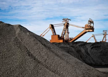 Manganese ore in stockpile at harbor loading site in Port Hedland, Pilbara, Western Australia.cReclaimer and stacker