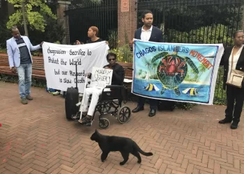 FILE - Protesters hold banners outside the World Court in The Hague, Netherlands, on Sept. 3, 2018, where judges listen to arguments in a case on whether Britain illegally maintains sovereignty over the Chagos Islands. Britain and the United States committed crimes against humanity when they forced the people of the Chagos Islands to leave their homes five decades ago to make way for a U.S. Navy base, a human rights group said Wednesday Feb. 15, 2023 as it called on the two governments to allow the Chagossians to return. (AP Photo/Mike Corder, File)