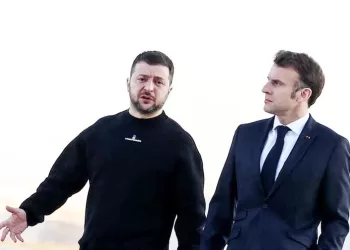 France's President Emmanuel Macron (R) and Ukrainian President Volodymyr Zelensky walk on the tarmac of Velizy-Villacoublay airbase as they prepare to board a flight together, en route to Brussels for a summit at EU parliament, on February 9, 2023. - Ukraine's President is set to attend an EU summit in Brussels on February 9, 2023, as the guest of honour where he will press allies to deliver fighter jets "as soon as possible" in the war against Russia. (Photo by MOHAMMED BADRA / POOL / AFP)