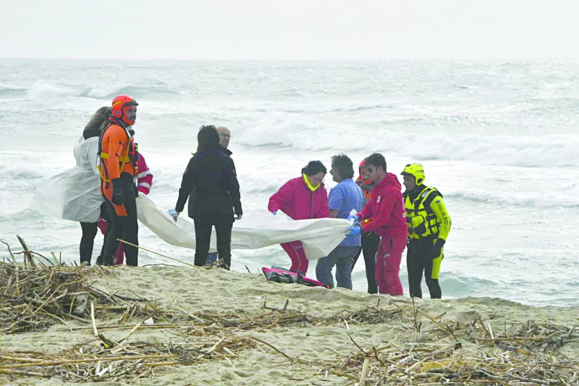 epa10491832 Italian firefighters and Red Cross personnel gather at the scene where bodies of migrants washed ashore following a shipwreck, at a beach near Cutro, Crotone province, southern Italy, 26 February 2023. Italian authorities said on 26 February that at least 30 bodies were found on the beach and in the sea near Crotone, in the southern Italian region of Calabria, after a boat carrying migrants sank in rough seas near the coast. About forty people survived the accident, Italian firefighters added. Authorities fear the death toll will climb as rescuers look for survivors.  EPA/GIUSEPPE PIPITA
