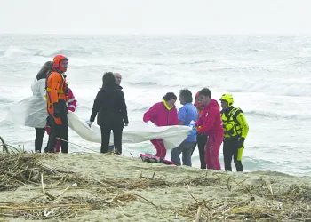 epa10491832 Italian firefighters and Red Cross personnel gather at the scene where bodies of migrants washed ashore following a shipwreck, at a beach near Cutro, Crotone province, southern Italy, 26 February 2023. Italian authorities said on 26 February that at least 30 bodies were found on the beach and in the sea near Crotone, in the southern Italian region of Calabria, after a boat carrying migrants sank in rough seas near the coast. About forty people survived the accident, Italian firefighters added. Authorities fear the death toll will climb as rescuers look for survivors.  EPA/GIUSEPPE PIPITA