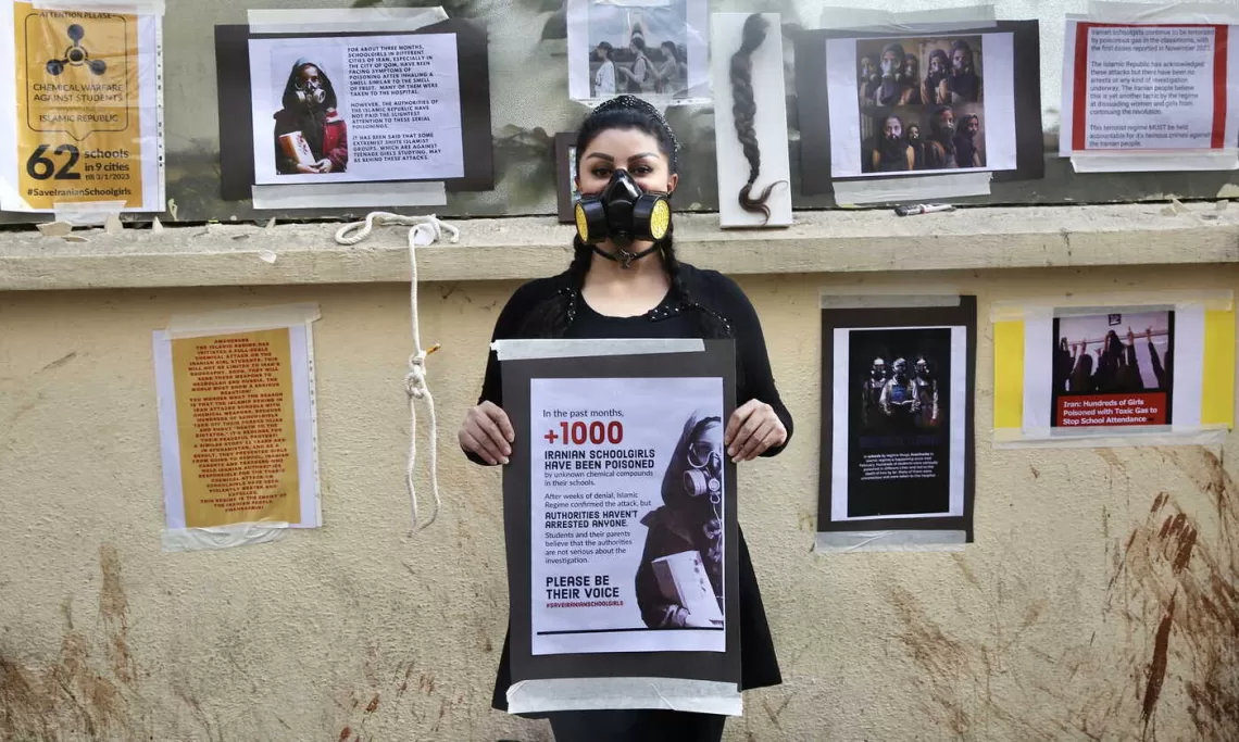 epa10504726 Nikoo Azad, a psychology student from Iran, wears a chemical fume respirator mask and holds a banner during a silent protest in Bangalore, India, 05 March 2023. Nikoo condemned the random toxic gas attacks on 26 girls' schools in Iran, for which no one has been arrested and no chemical agent has been found responsible for the mysterious poisoning of girls.  EPA/JAGADEESH NV