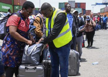 People fleeing war-torn Sudan queue to board a boat from Port Sudan on April 28, 2023. - Fighting raged in Sudan despite rival forces agreeing to extend a truce aimed to stem nearly two weeks of warfare that has killed hundreds and caused widespread destruction. (Photo by AFP)