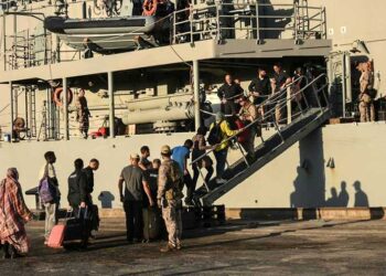 In this picture taken on May 5, 2023, people from various nationalities board the Spanish frigate Reina Sofia during an evacuation from Port Sudan toward Saudi Arabia, as violence continues between two rival Sudanese generals. - The US and Saudi governments confirmed direct talks between the warring Sudanese army and the Rapid Support Forces would start in Jeddah on May 6, 2023, even as fighting showed little signs of abating in the Sudanese capital. (Photo by AFP)