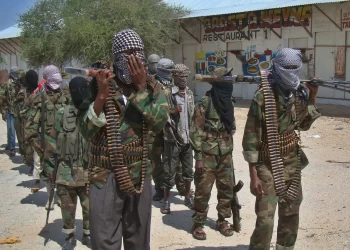 Al-Qaeda linked al-shabab recruits walk down a street on March 5, 2012 in the Deniile district of Somalian capital, Mogadishu, following their graduation. The walls of the former Shebab base in Baidoa, Somalia, are littered with rudimentary drawings of machine guns and tanks, a note reading "Fear God, don't write on these walls" and a sketch of an Al-Qaeda flag, homage to the rebel group's international allies.  The crumbling building is now occupied by Ethiopian troops who nearly two weeks ago forced Shebab rebels out of Baidoa, their former Shebab stronghold and Somalia's third-largest city.  AFP PHOTO/Mohamed ABDIWAHAB (Photo credit should read Mohamed Abdiwahab/AFP via Getty Images)