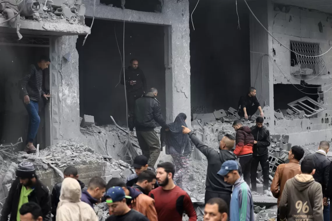 Palestinians look for survivors in the rubble of a building damaged during an Israeli strike on Rafah in the southern Gaza Strip on November 20, 2023, amid continuing battles between Israel and the militant group Hamas. (Photo by MAHMUD HAMS / AFP)