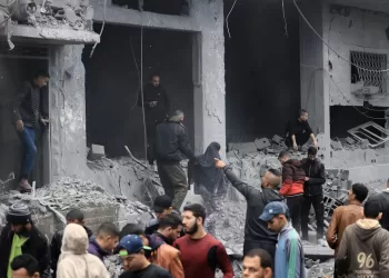 Palestinians look for survivors in the rubble of a building damaged during an Israeli strike on Rafah in the southern Gaza Strip on November 20, 2023, amid continuing battles between Israel and the militant group Hamas. (Photo by MAHMUD HAMS / AFP)