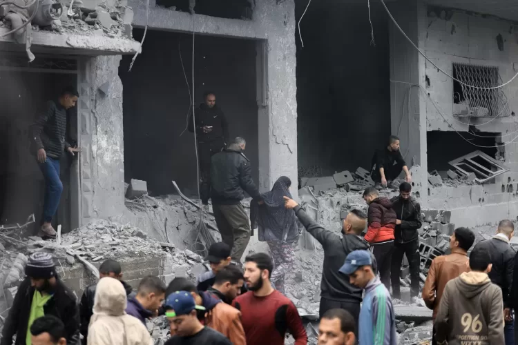 Palestinians look for survivors in the rubble of a building damaged during an Israeli strike on Rafah in the southern Gaza Strip on November 20, 2023, amid continuing battles between Israel and the militant group Hamas. (Photo by MAHMUD HAMS / AFP)