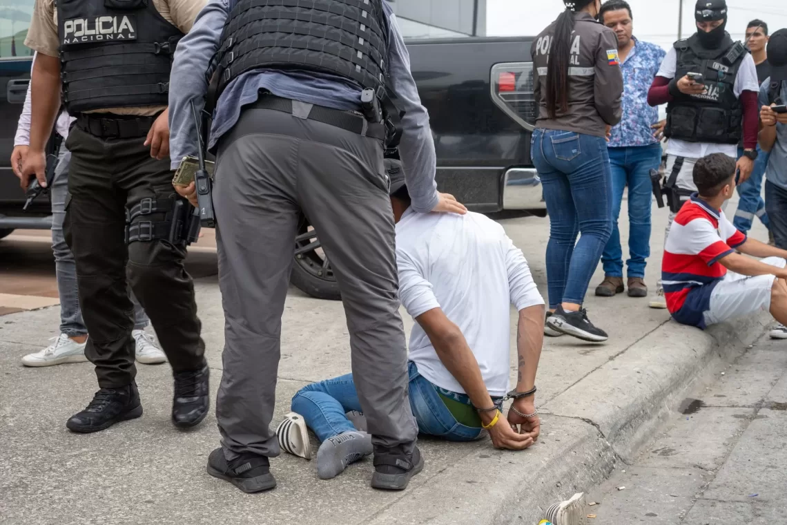 epa11066686 Police arrest a suspected criminal a few blocks from the headquarters of TC television station where armed, hooded men entered and subdued staff during a live broadcast, in Guayaquil, Ecuador, 09 January 2024. Agents of the National Police of Ecuador arrested at least thirteen people after entering the facilities of TC Television hours after a group of heavily armed men interrupted live programming, threatening employees with rifles, grenades and explosives.  EPA/Mauricio Torres